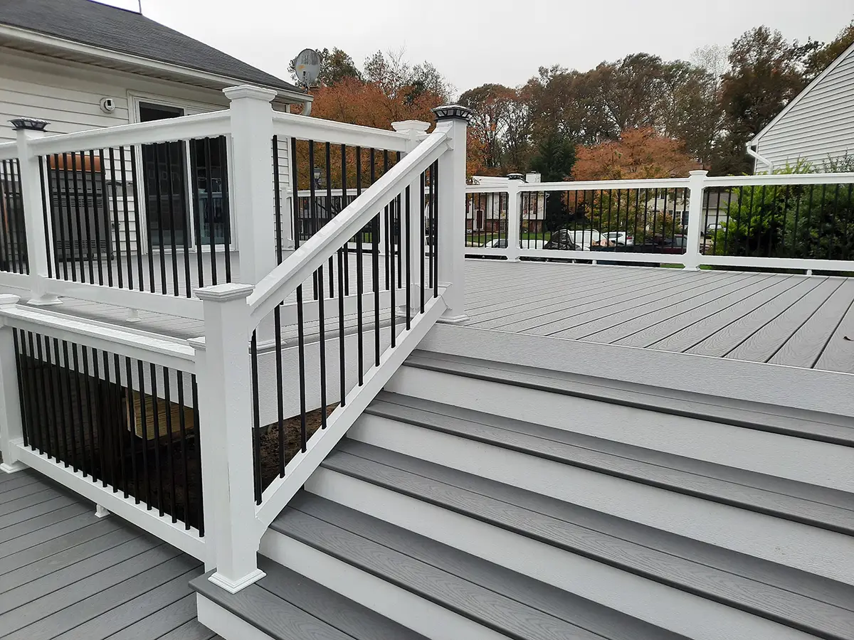 Multi-level composite deck installation in Coralville, IA. This deck features black metal railings and built-in lighting.